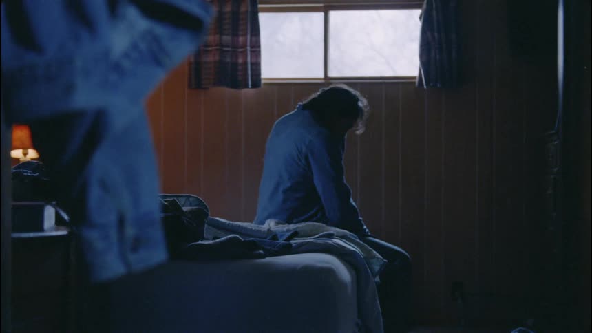 A man sits in the dark bedroom