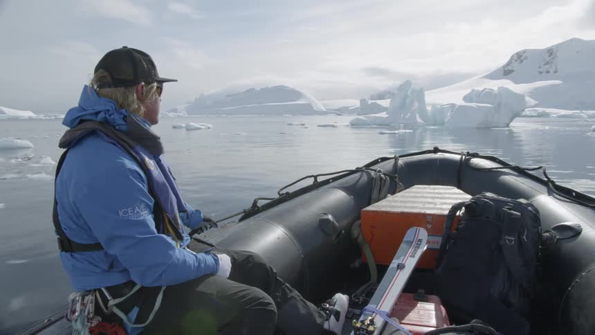 Man rides on a motorized raft in an icy lake