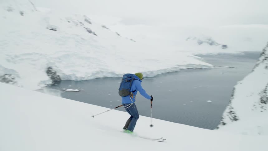 A skier glides down a snowy mountainside