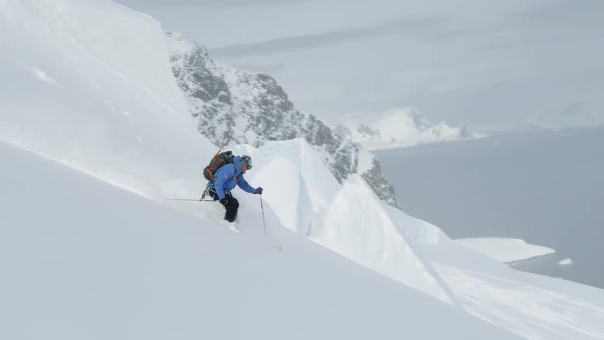 Person skis down a large snowy mountain