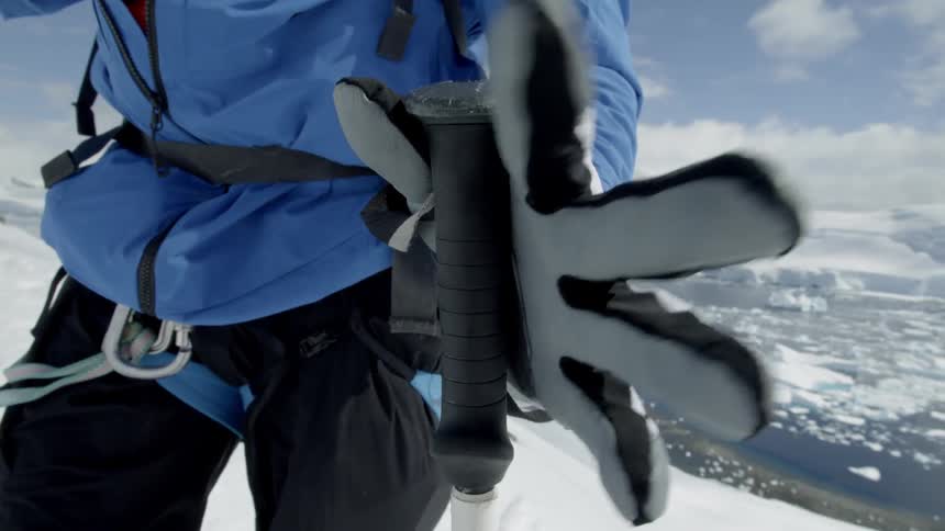 The skier tightens his grip on his poles