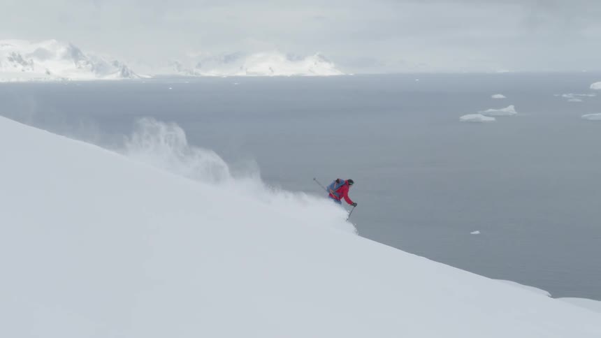 A skier glides down a snowy mountainside