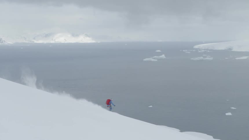 A skier glides down a snowy mountainside