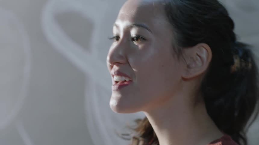 A teacher smiles and then looks back at the board