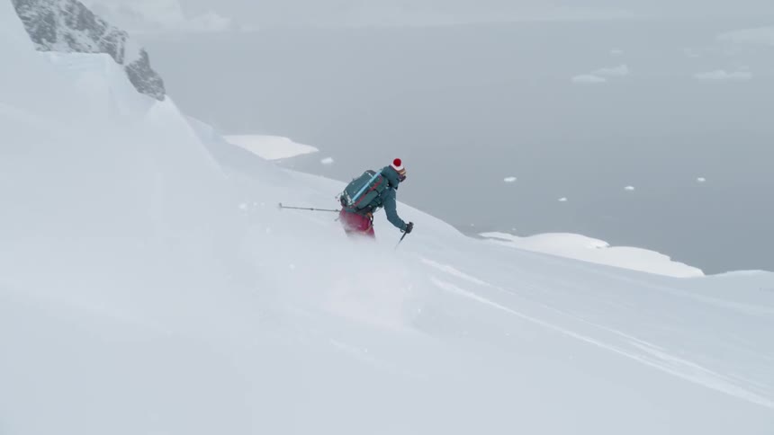 Person skis down a large snowy mountain