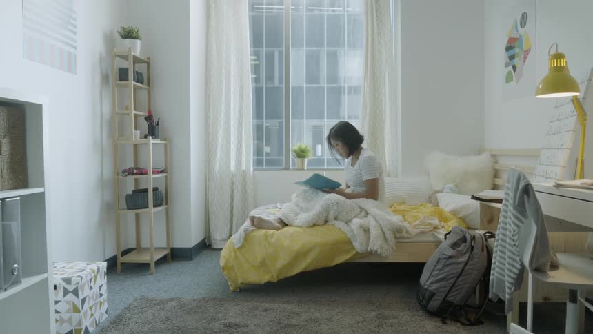 A woman writes in a notebook in bed
