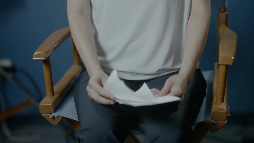 A woman sits on a chair looking through some papers