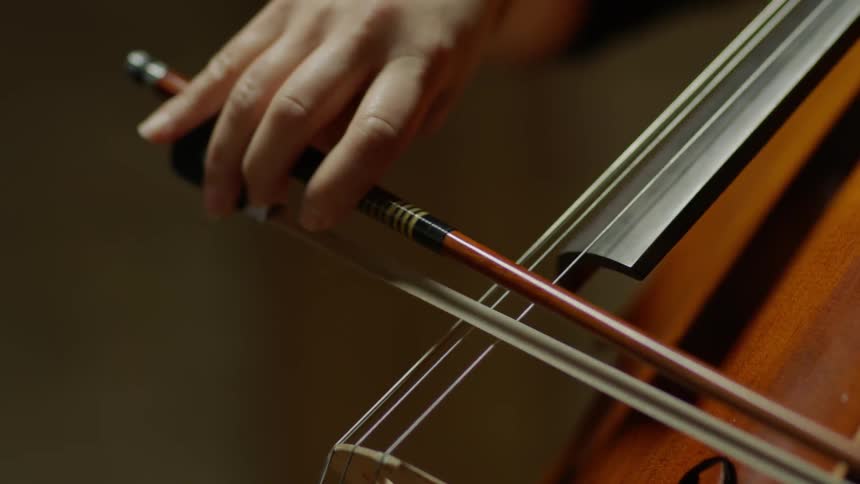 Bow slides across the strings on a violin