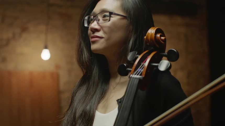 Woman smiles and holds a cello