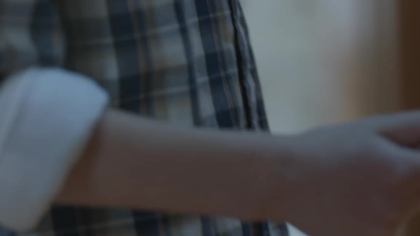 Child holds a piece of small white chalk in his hand and writes on a chalkboard