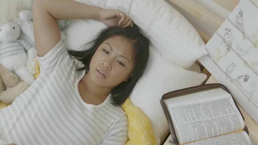 A woman is laying in bed before getting up