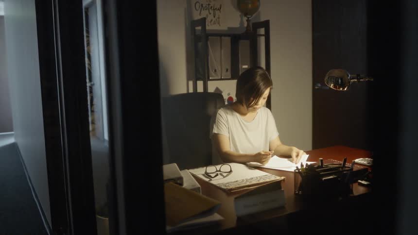 A woman is writing inside of her office