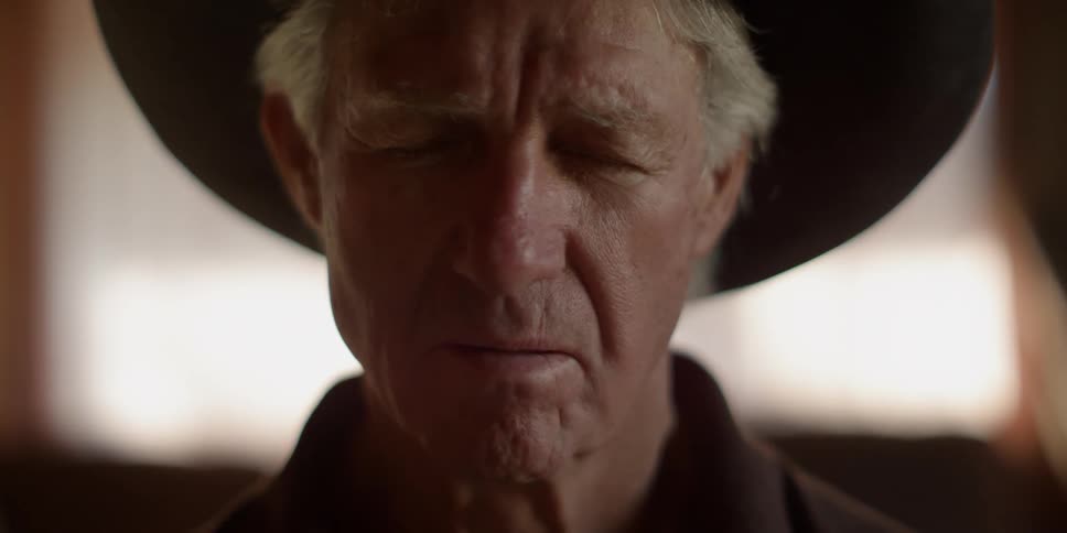 A cowboy with his eyes closed