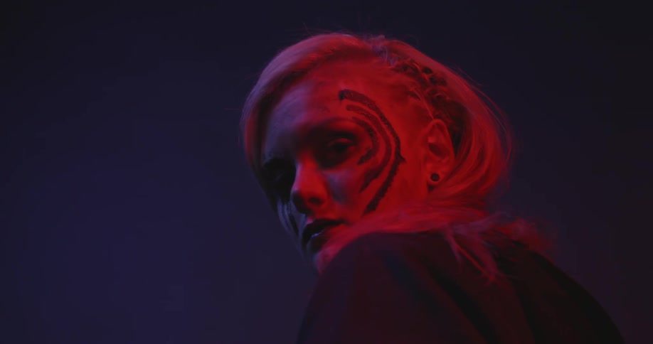 A woman wears face paint in the dark