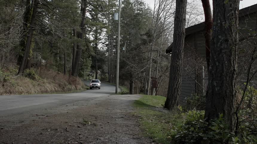 A vehicle drives on a rural road