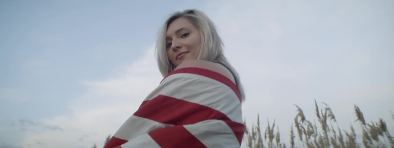 Smiling woman wraps a flag around herself