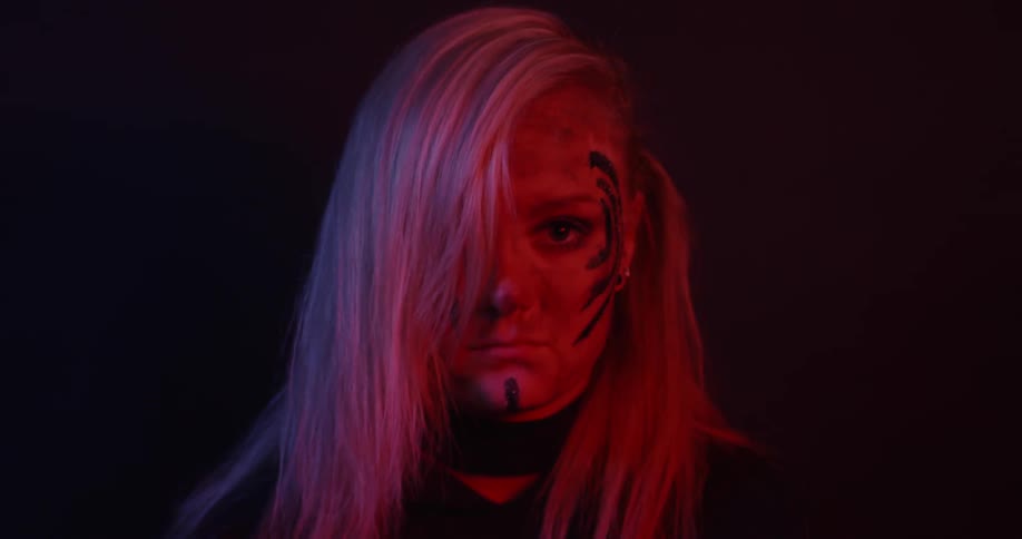 A woman wears face paint in the dark