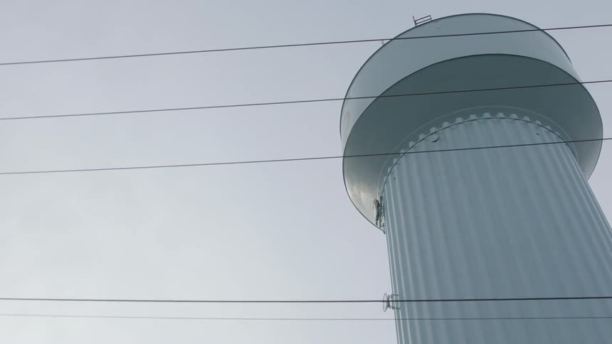 A water tower is next to a road