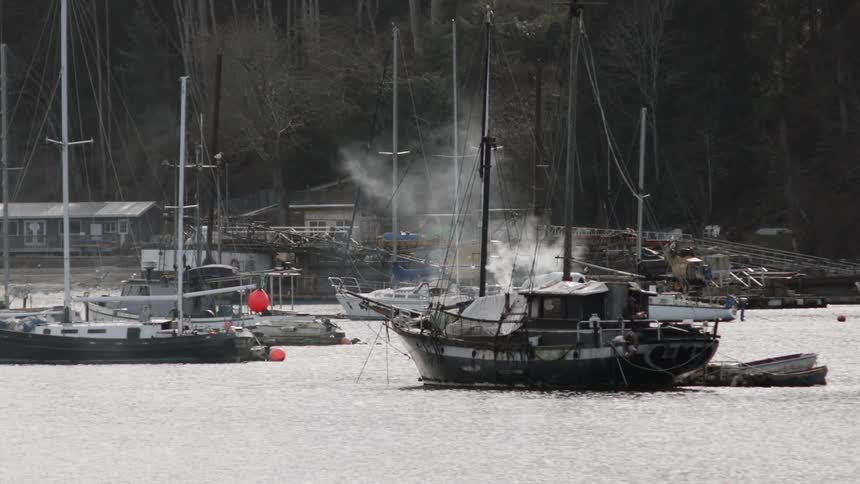 Steam is rising from one of the docked boats