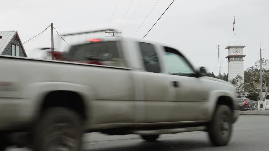 Van drives on a curving road through a small town