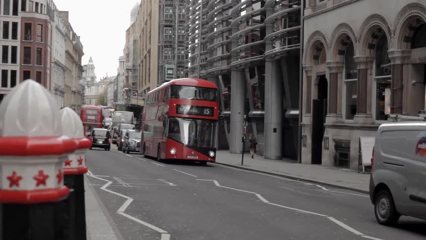 Cars and buses drive on a city street