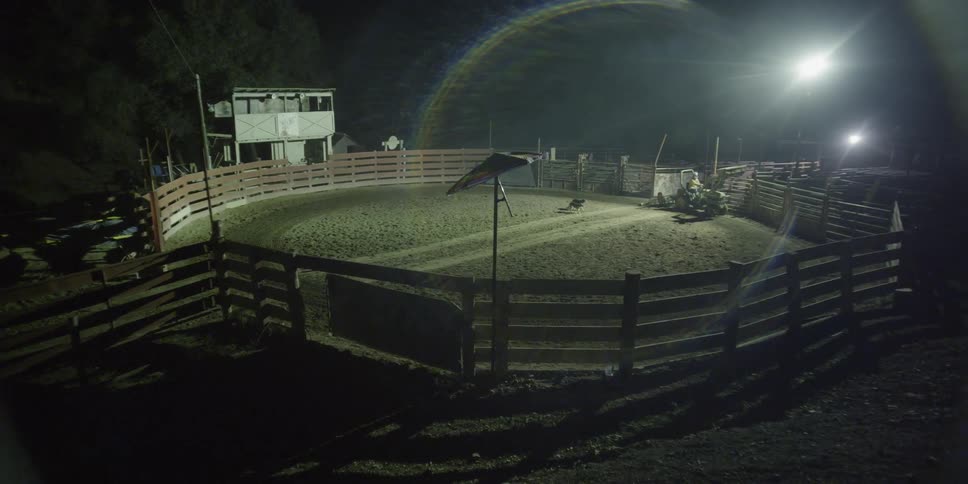 A person drives a tractor around a fenced in area