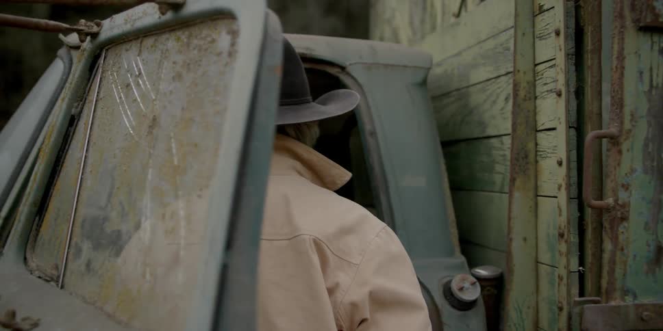 A cowboy opens a dirty truck door