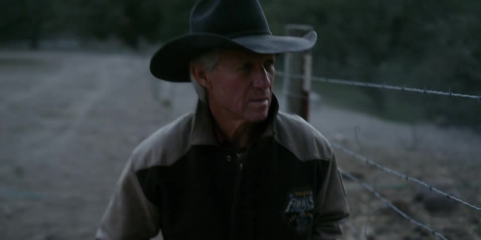 A cowboy walks on a ranch
