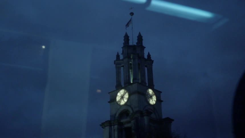 Large clock in a tower shines at night