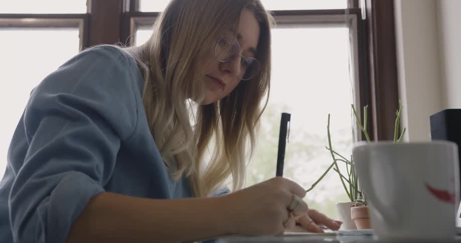 Female Business Owner or College Student writes at a desk