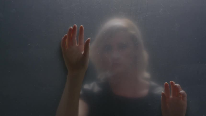 Blonde woman touching a screen-like area in front of her