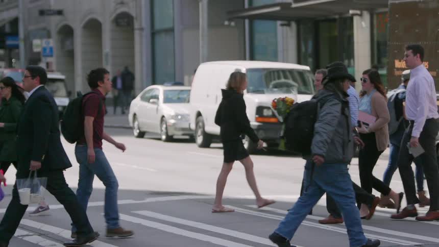 People cross a city street at the crosswalk