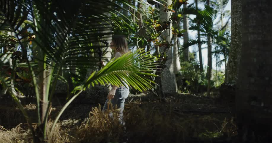 A woman is hiking through the forest with a camera