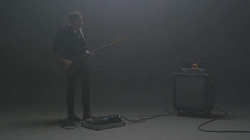 A guitarist plays in an empty room