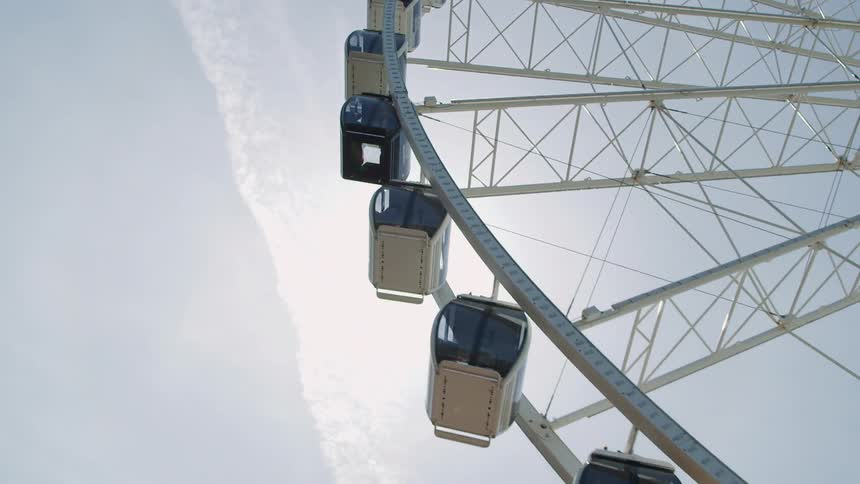 A ferris wheel rotates into the sky