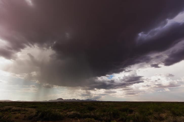Large storm clouds travel over the field ahead