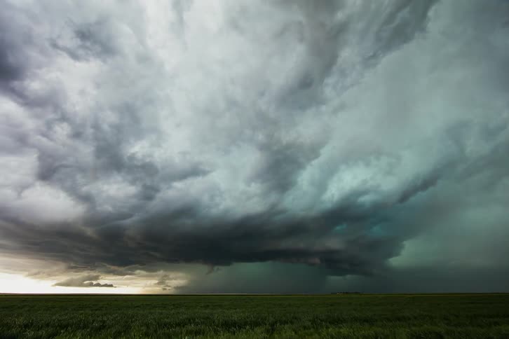 Storm and rain clouds gather and move over a field