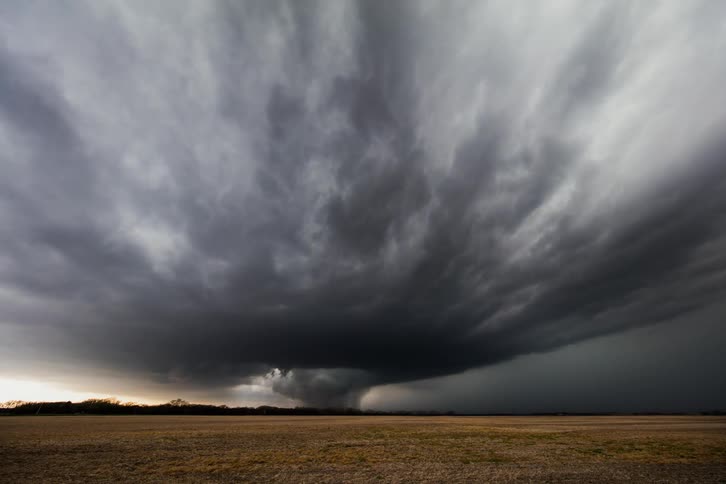 A storm brews over an open field