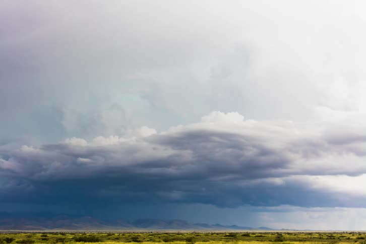 Lightning is flashing amid storm clouds as they move during the day