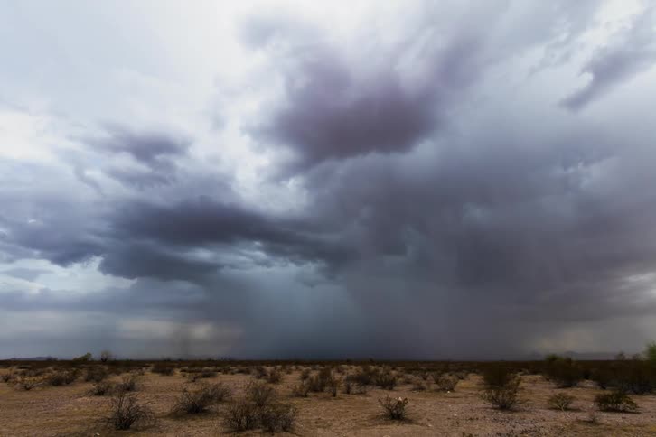 A storm brews over an open field