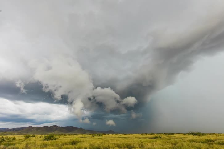A storm is blowing across a prairie in daylight