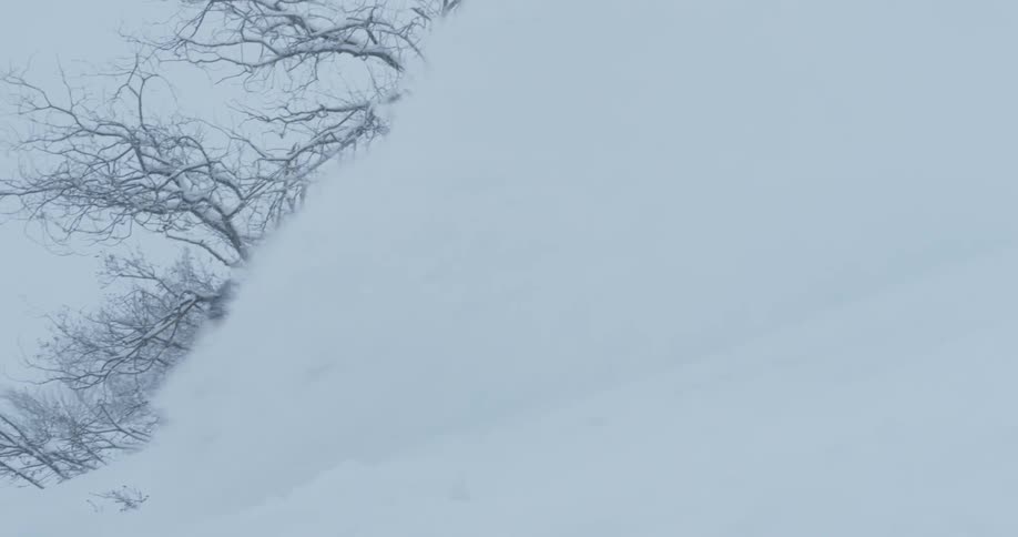 A snowboarder plows through the deep powder snow