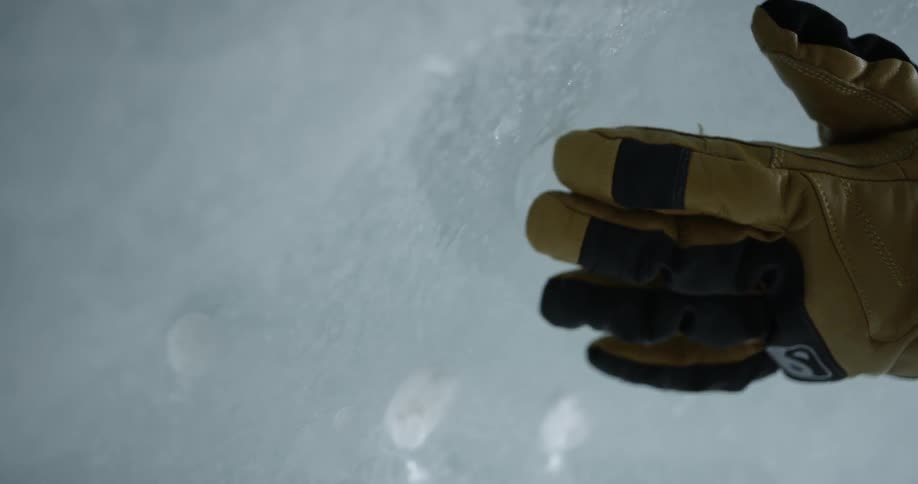 A person rubs a glove on ice