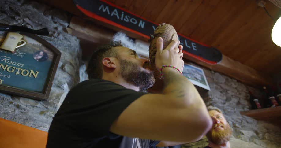 A man takes a drink from a circular dish