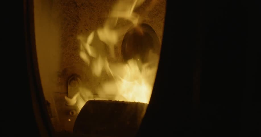 The dark oven is bright with flames