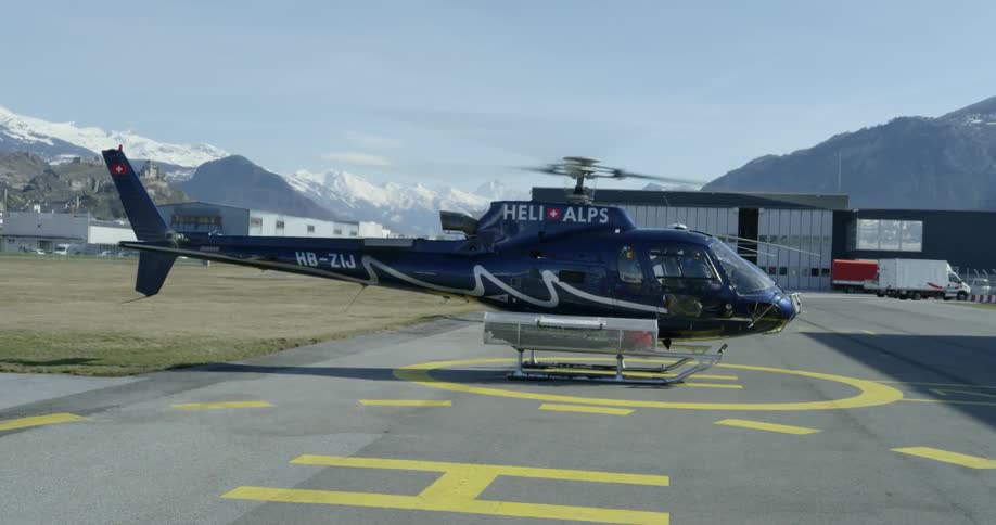 Helicopter with its blades spinning before take off from the ground on a clear day