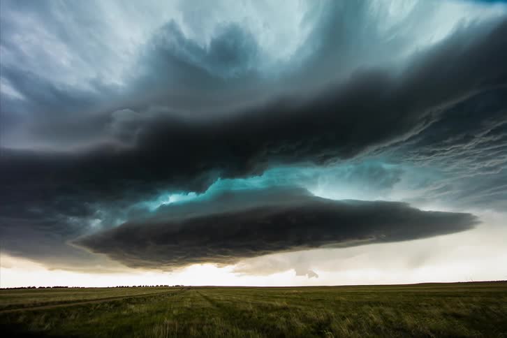 A storm brews over an open field
