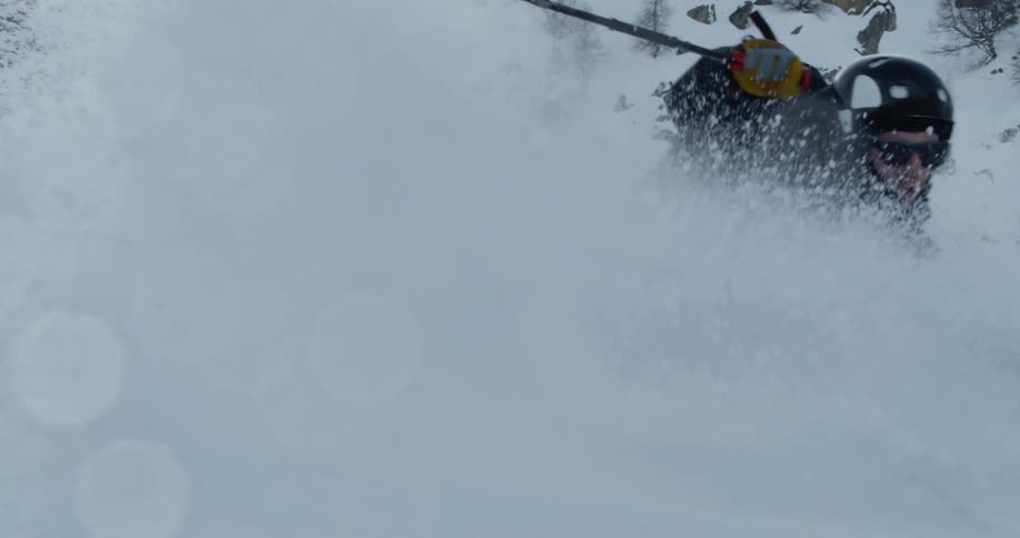The man makes a steep turn in the deep snow on skis