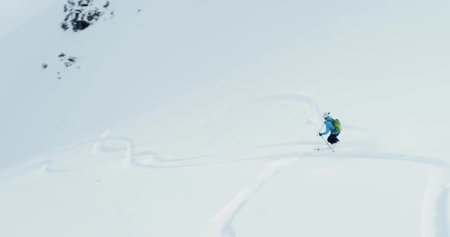 A person is skiing down the slope fast