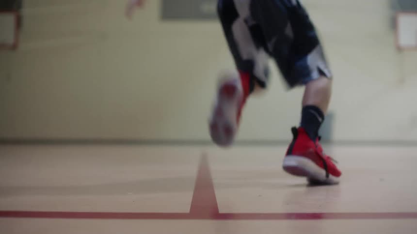 Person sprinting from one side of a gym to the other and then sprinting back